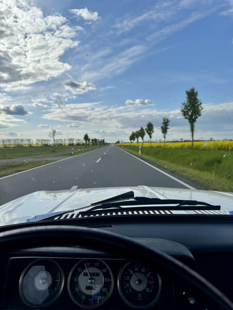 Blick durch die Windschutzscheibe des BMW 2002 auf freier Landstraße